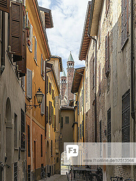 Italy  Province of Cremona  Cremona  Old empty alley with towers of Cremona Cathedral in background