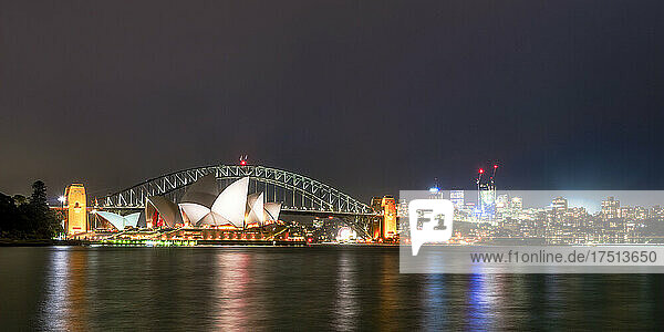 Illuminated Sydney Harbor Bridge and buildings over river against sky at night  Australia