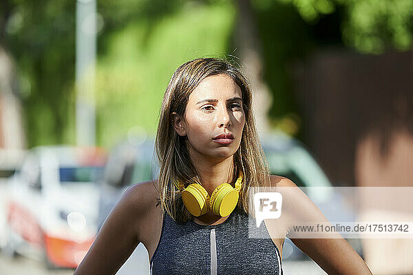 Woman with headphones standing in city