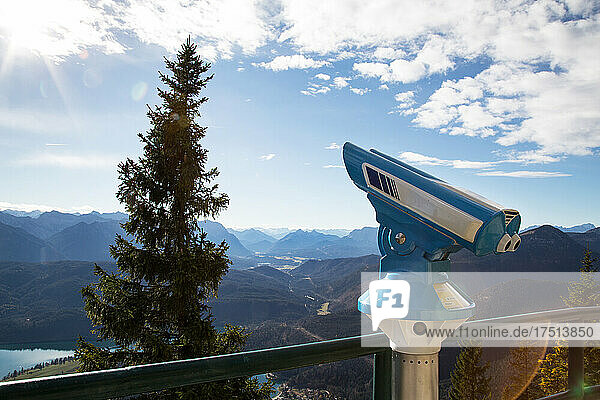 blaues Fernrohr am Aussichtspunkt Herzogenstandbahn am Walchensee mit Sicht auf das Karwendelgebirge