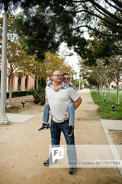 Dad Giving Ten Year Old Son a Piggyback Ride in San Diego