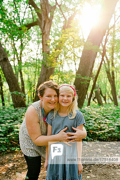 Straight on portrait of a mother and daughter together in the forest