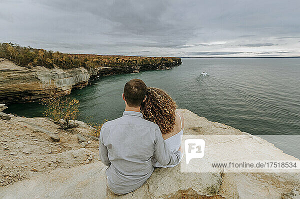 Couple hold each other looking over Lake Superior  Michigan