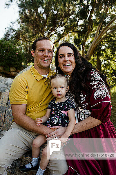 Family of Three Smiling for Camera in Garden in California