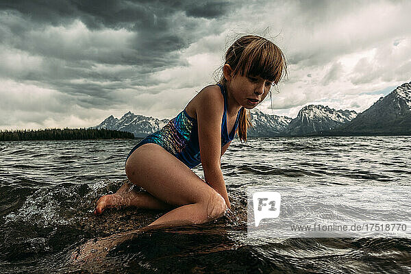 Young girl swimming in mountain lake