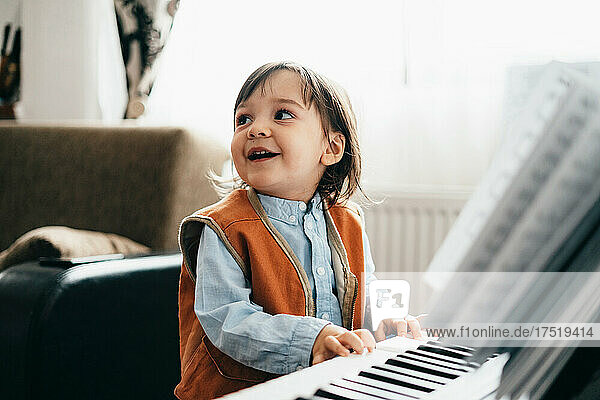 Happy child plays the piano