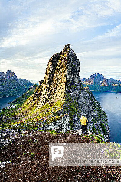 Person standing in front of tall Segla Mountain and fjords at dawn  Senja island  Troms county  Norway  Scandinavia  Europe