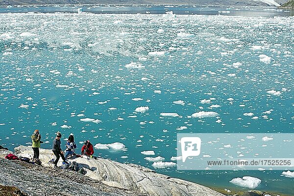 Menschen stehen an in einem Fjord mit Eis und Eisbergen  Gletscher  Arktis  Knud Rasmussen Fjord  Ostgrönland  Grönland  dänemark  Nordamerika