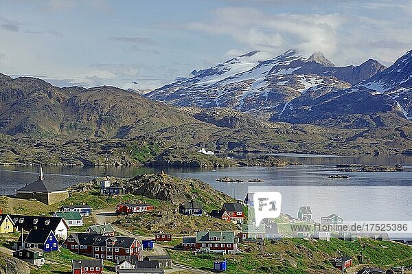 Häuser verteilen sich weitläufig  karge Berge mit Schnee und ein Fjord  Tasilaq  Arktis  Ostgrönland  Grönland  Dänemark  Nordamerika