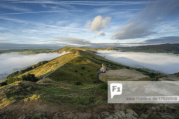 A walker sat looking across The Great Ridge and Mam Tor  Peak District  Derbyshire  England  United Kingdom  Europe