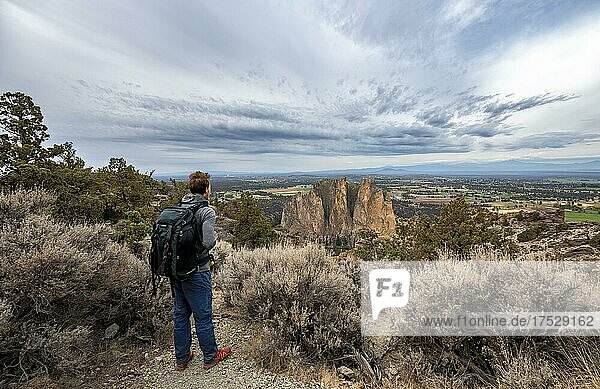 Young man on hiking trail  looking into the distance  view of canyon with rock formations  Smith Rock State Park  Oregon  USA  North America