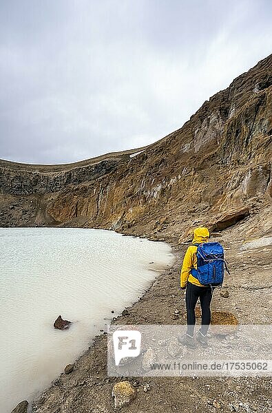 Hiker at the crater lake Víti in the crater of the volcano Askja  mountain massif Dyngjufjöll  Iceland  Europe