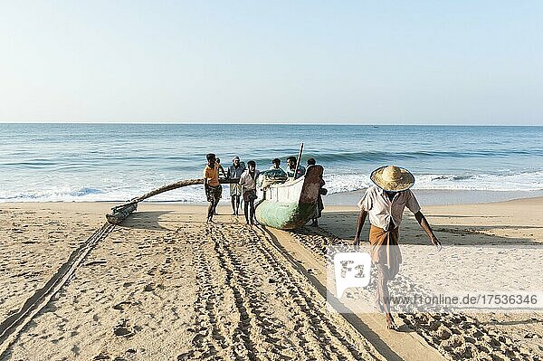 Fishermen pull fishing boat out of the sea onto the sandy beach  dugout canoe with outrigger  Darwins Beach  Wella Odaya near Ranna  Southern Province  Sri Lanka  Indian Ocean  Asia