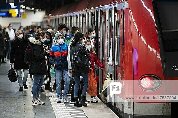 Group of people wearing face masks boarding the S-Bahn at Marienplatz station  Munich  Bavaria  Germany  Europe