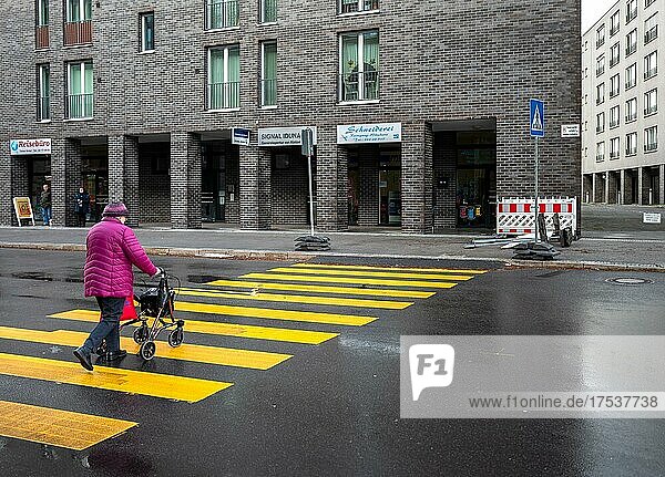 Seniorin mit Rollator überquert die Straße  Berlin  Deutschland  Europa