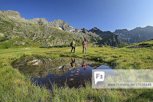 Tourists hiking by sea eye puddle at winter vacation  Valgaudemar  Ecrins National Park  France