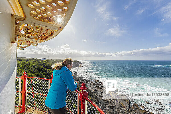 Australien  Victoria  Cape Otway  Touristin  die vom Leuchtturm von Cape Otway aus den Blick auf die Bassstraße bewundert
