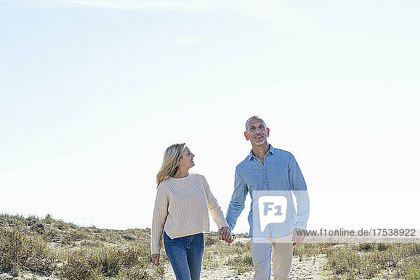 Couple walking together at dunes