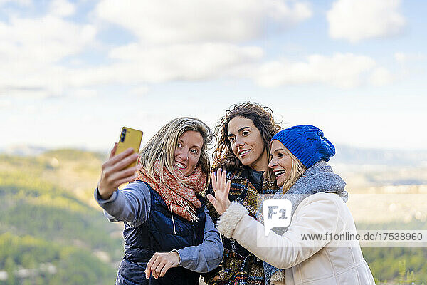 Woman taking selfie with friends at park