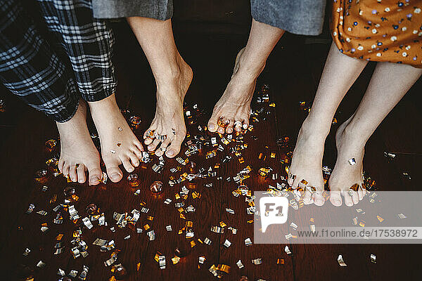Confetti on legs of family and floorboard