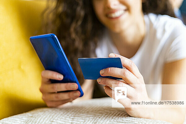 Frau betreibt Online-Banking per Kreditkarte und Smartphone