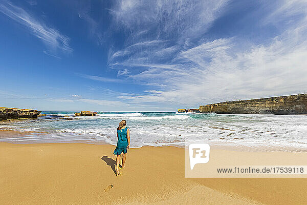 Female tourist walking alone along Sherbrook River Beach in Port Campbell National Park