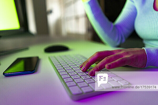 Working woman typing on keyboard on desk at home office