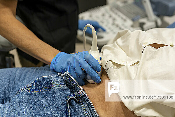 Doctor performing ultrasound examination on patient stomach