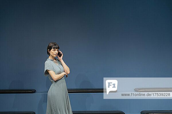Selbstbewusste Geschäftsfrau telefoniert im blauen Sitzungssaal