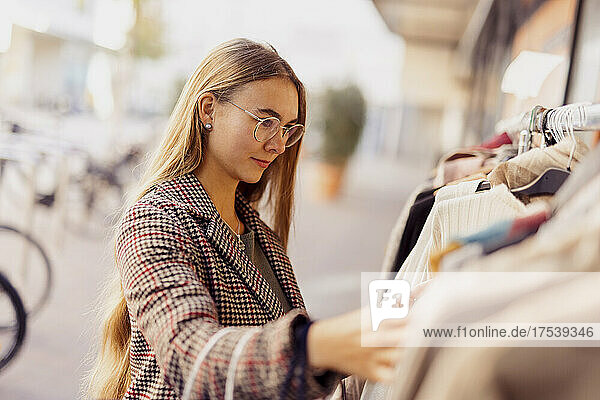 Young woman shopping clothes outside store