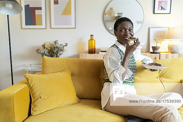 Happy woman enjoying breakfast being at home