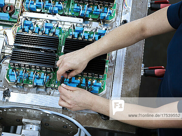 Technician connecting wires on circuit board