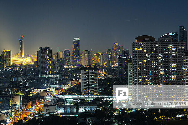 Modern cityscape with illuminated buildings at night  Bangkok  Thailand