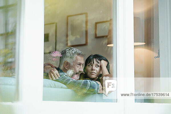 Heterosexual couple seen through window of house
