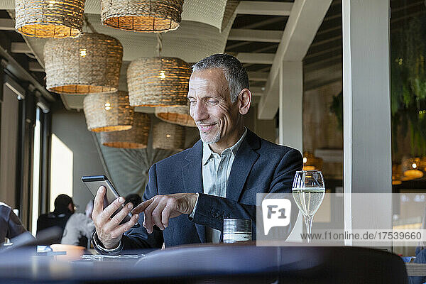 Lächelnder Geschäftsmann mit Tablet-PC im Restaurant