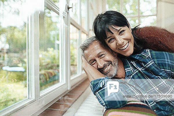 Happy woman leaning on man at home