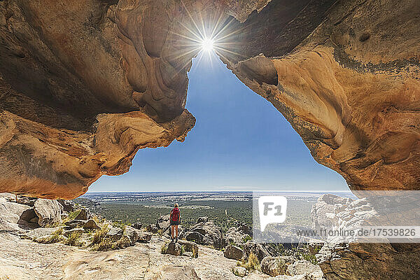 Australia  Victoria  Female tourist admiring surrounding landscape from entrance of Hollow Mountain cave in Grampians National Park