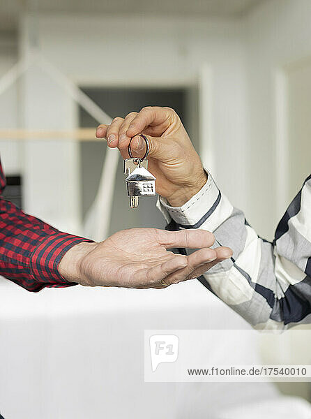 Real estate agent giving house key to customer