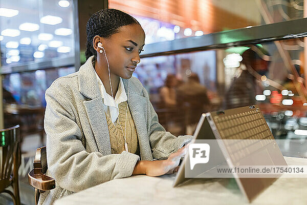 Girl using touch screen laptop at cafe