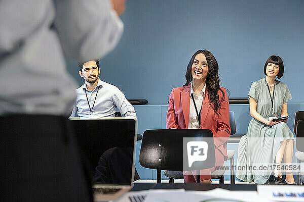 Smiling business people attending meeting at workplace