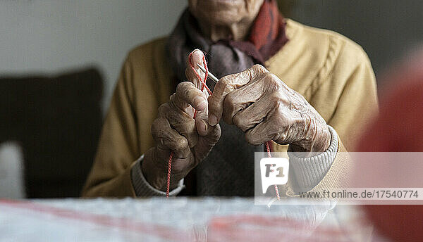 Retired senior woman knitting at home