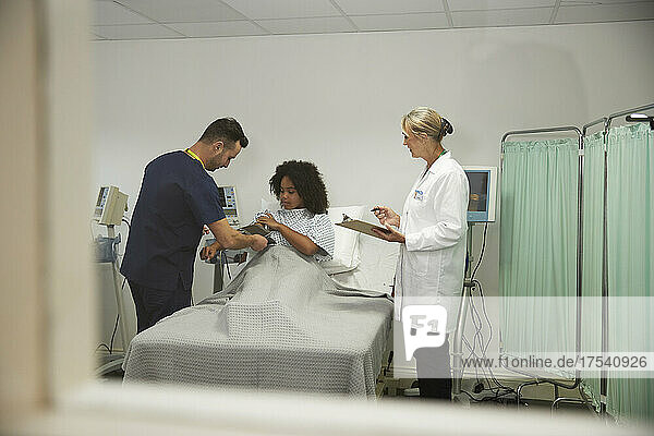 Healthcare worker checking blood pressure of patient at hospital
