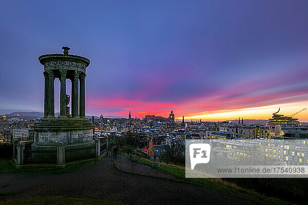 UK  Scotland  Edinburgh  Moody sky over city at dusk with Dugald Stewart Monument in foreground