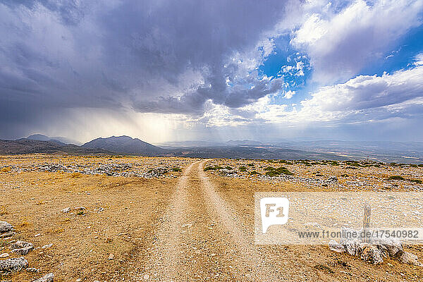 Cloudscape over empty dirt road in Andalucia  Spain  Europe