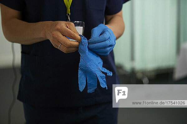 Nurse wearing surgical gloves in medical room