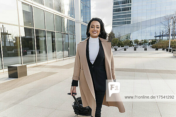 Geschäftsfrau geht mit Gepäck auf Fußweg