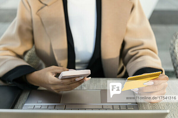 Geschäftsfrau bezahlt per Kreditkarte auf dem Smartphone