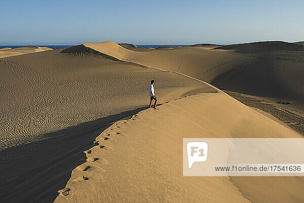 Young man walking on sand dune at sunset  Grand Canary  Canary Islands  Spain