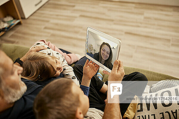 Grandfather with grandchildren doing video call on tablet PC at home