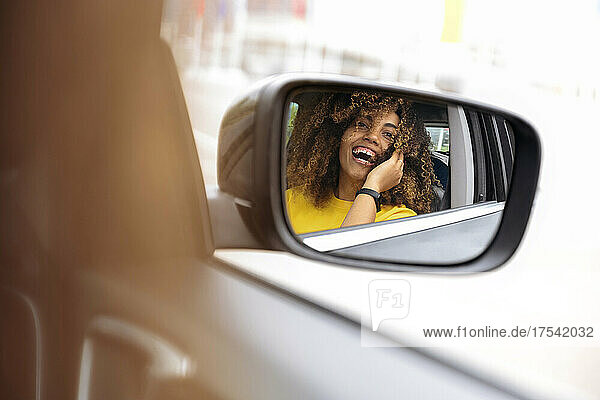 Reflection of woman in side-view mirror of car